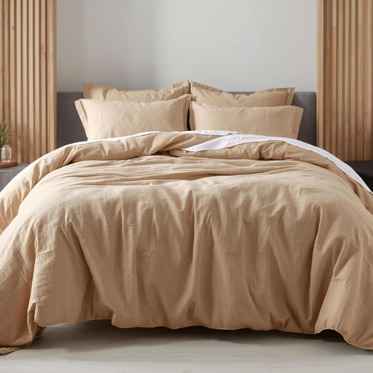 Beige bedding set on a bed with a neutral background